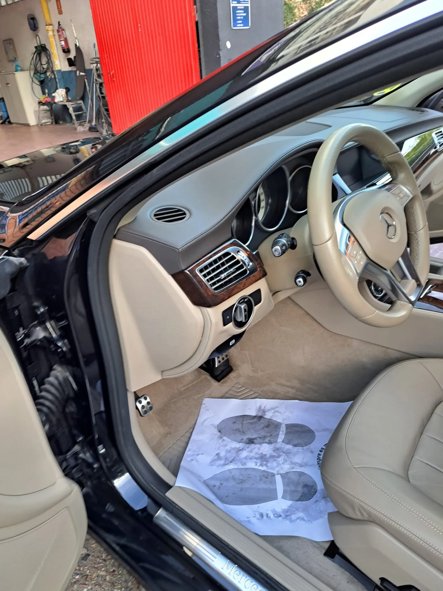 Protector desechable en el suelo del coche del cliente para cuidar el interior durante la reparación en el Taller Mutua Madrileña en Torrejón de Ardoz